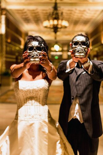 halloween wedding ideas photo the bride and groom cover their faces with their skulls beautifuldayphotography