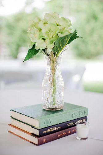 rustic wedding decor centerpiece with books and flower in glass jennifer thornhill photography