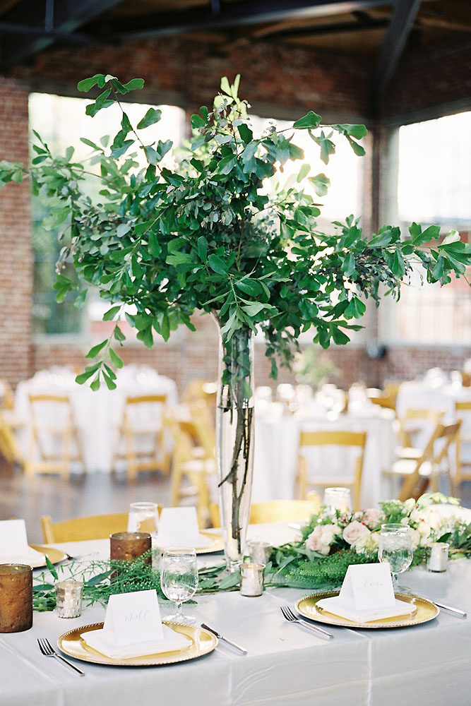 tall wedding centerpieces in a high glass vase twigs with leaves heather payne photography