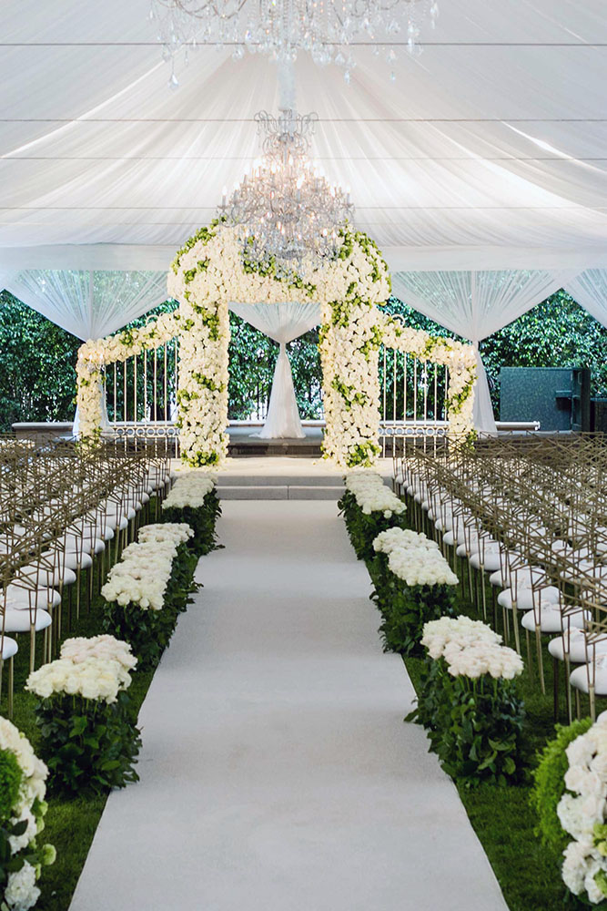 wedding tent flower arch with white flowers and chic chandeliers samuel lippke studios