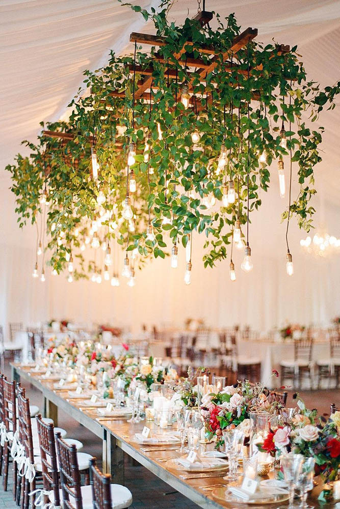 wedding tent long table flowers under above him greens light bulbs leaf studios via instagram