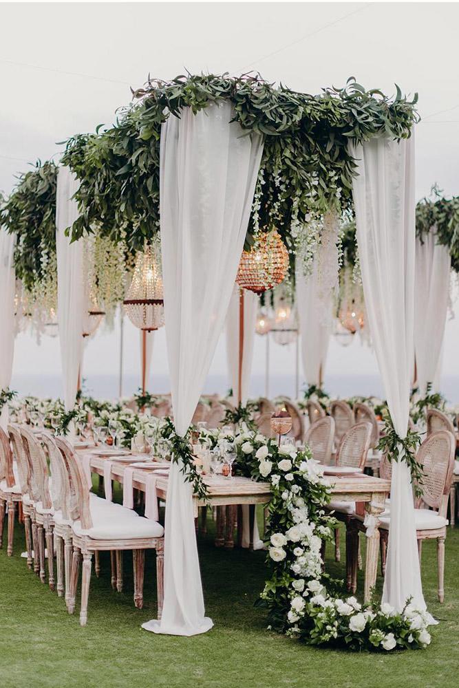 wedding tent white cloth and greenery with roses tablerunner and hanging chandelier fontainephoto