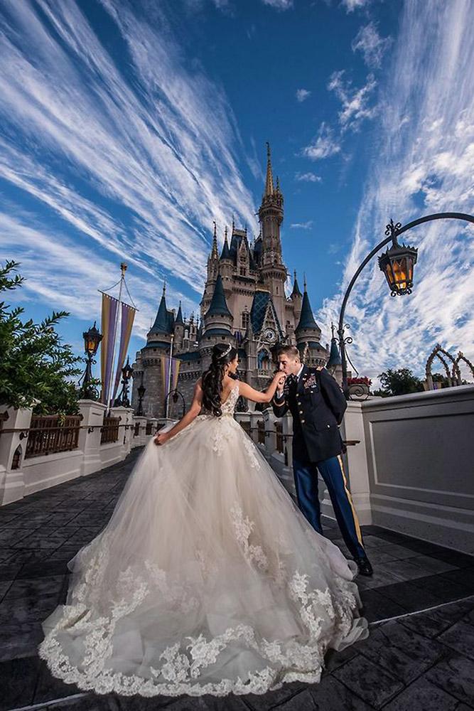 disney wedding the groom kisses the hand of the bride against the background of the castle disney fine art photography