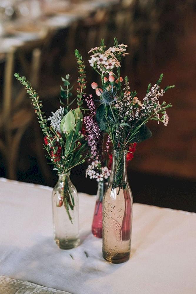 rustic wedding centerpieces wildflowers in glass bottles raconteur photography