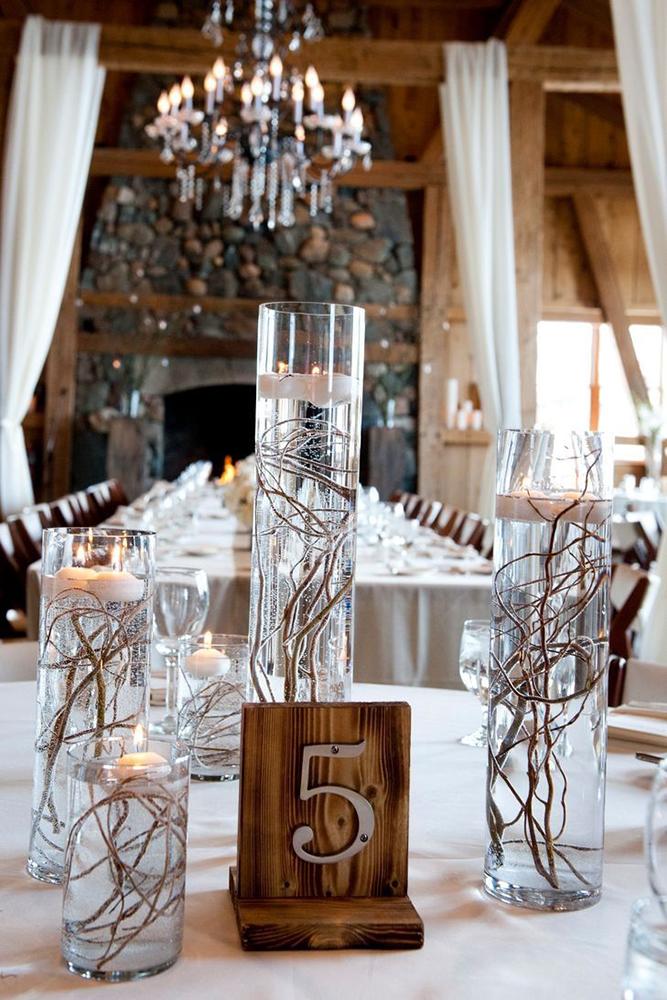 rustic wedding centerpieces wooden branches in tall vases vith candles brintonstudios