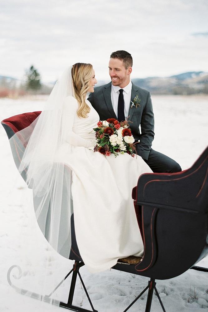 winter wedding photo ideas couple sitting in sledge rebeccahollis
