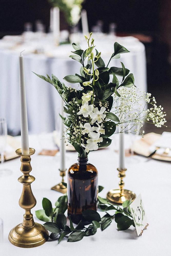 bohemian decor ideas glass bottle with white flowers and gold candlesticks