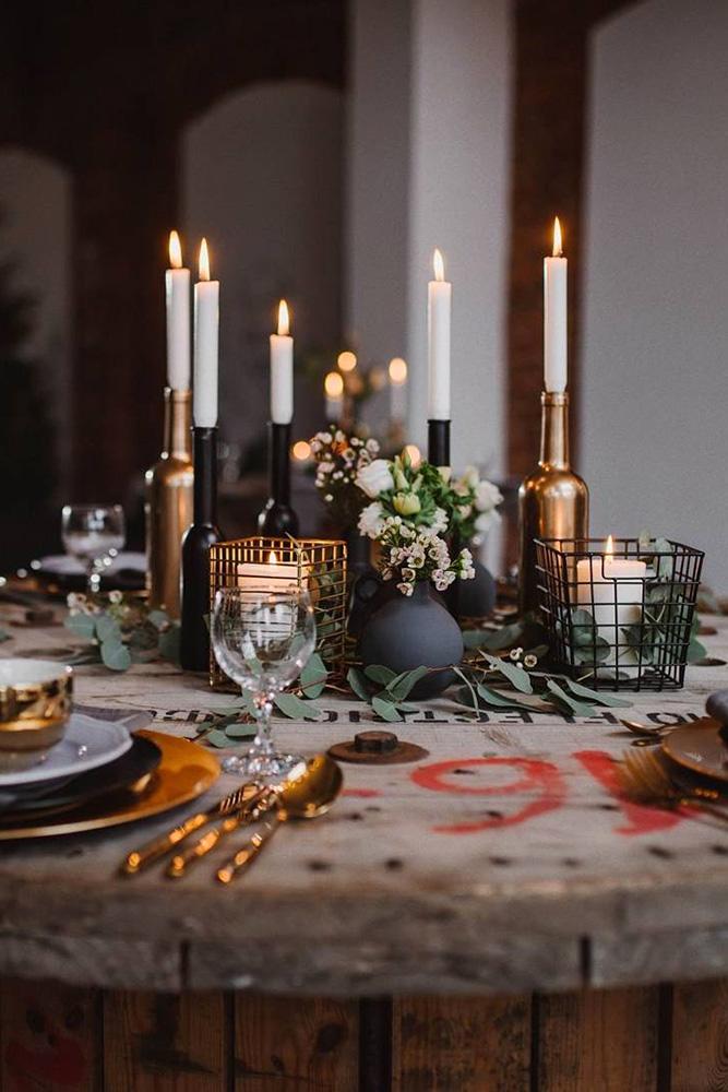 bohemian decor ideas table on wooden reel with candles greenery flowers in black vases ajem_stories