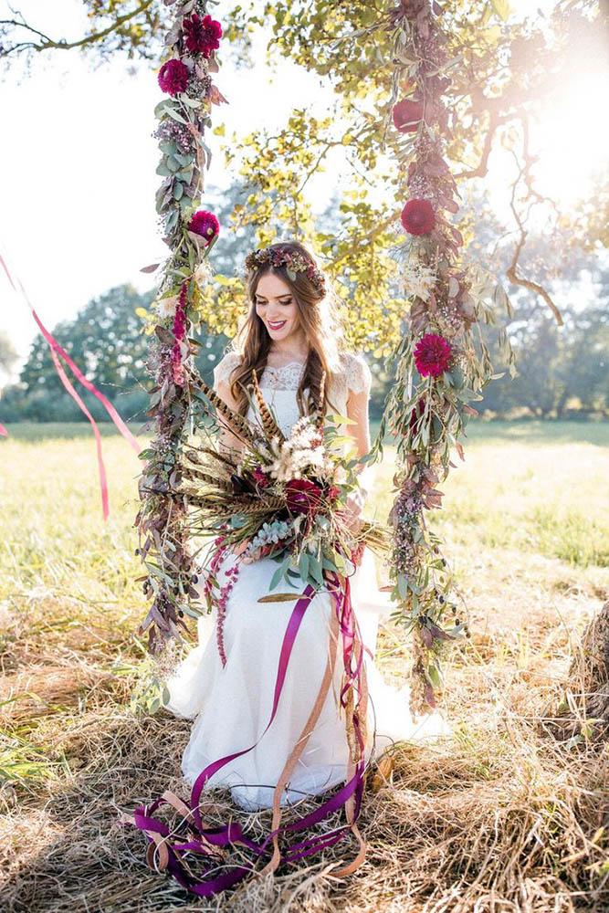 bohemian décor ideas boho bride with a bouquet on a swing decorated with flowers andreasnusch via instagram