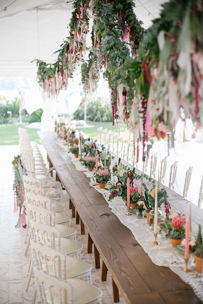bohemian décor ideas long wooden table decorated with flowers and candles suspended greenery irene fucci