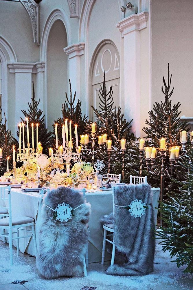 christmas wedding cozy winter reception with candles pine trees and fur on the chairs mel yates