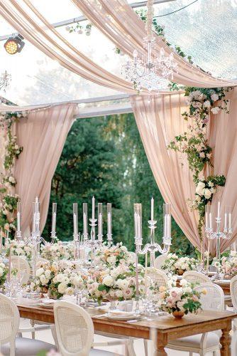 dusty rose wedding tent with cloth and greenery with flowers and candles on tables roman_ivanov_weddings