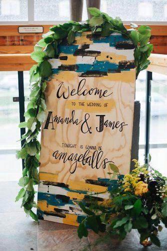 mustard wedding wooden bright painted with black white and blue welcome sign with greenery jennifer see studios