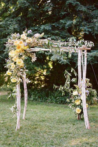 wedding colors 2019 mustard yellow flowers and greenery on rustic wooden bridal arch christina mcneill