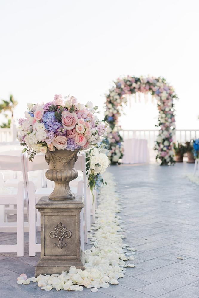 spring wedding decor aisle with gentle pink blue lilac flower petals and stone vaces valorie darling photography