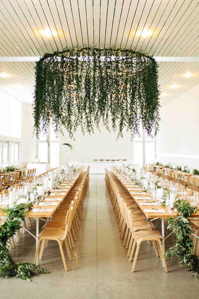 spring wedding decor indoor wedding reception with hanging greenery tablerunners nicholsphotographers
