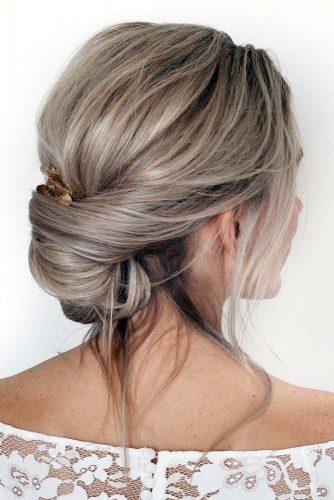 bohemian wedding hairstyles simple low messy updo with loose strands of hair nicoledrege