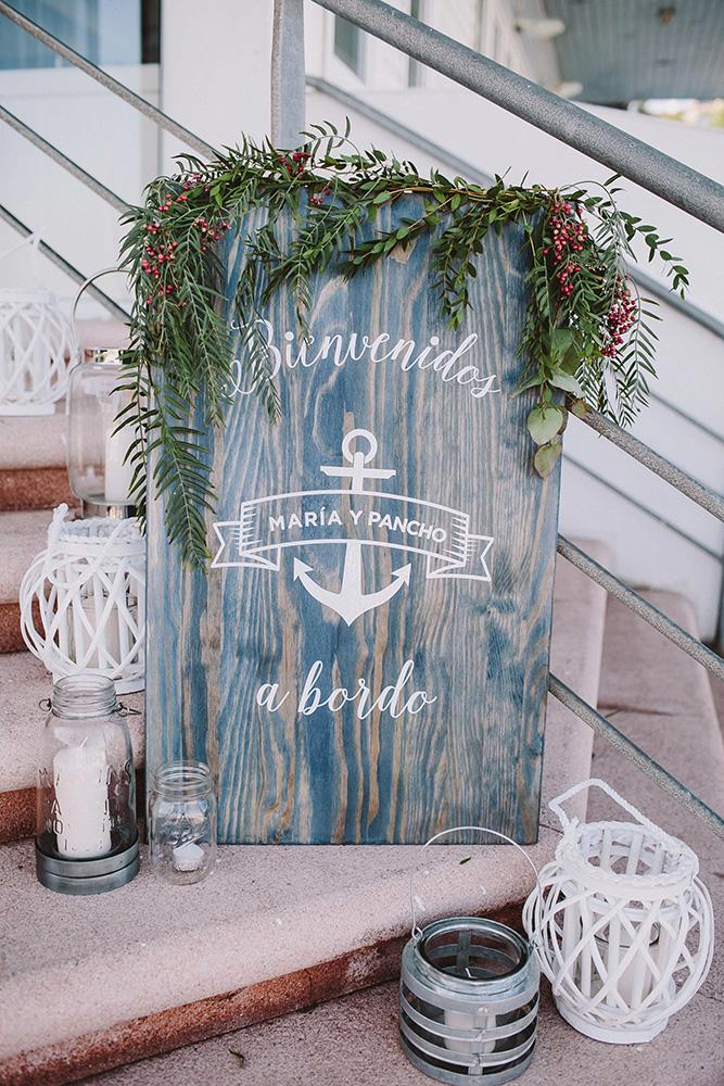 nautical wedding grey wooden sign with anchor greenery and candles raquel benito