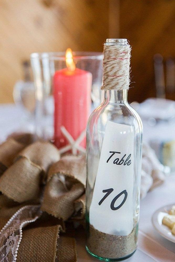 nautical wedding ideas glass bottle with stand and tablenumber coral candle elizabeth henson photos