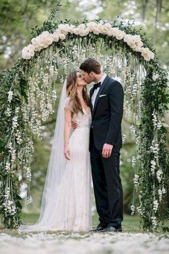 sage green wedding backdrop with handing white roses and greenery arch sean money + elizabeth fay