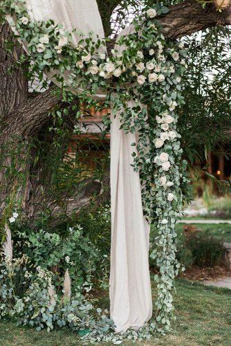 sage green wedding backdrop with white roses greenery and cloth almond leaf studios
