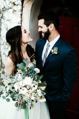 sage green wedding boutonniere and a bouquet in the photo with the happy bride and groomjessie schultz photography