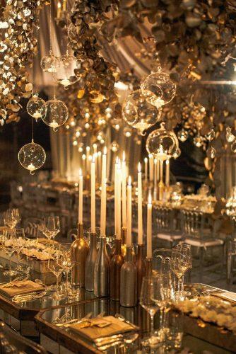 modern wedding decor gold reception table with candles in bottle candlesticks featured floral