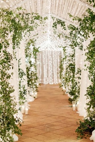 natural wedding décor barn aisle with lanterns garland and greenery imryanray