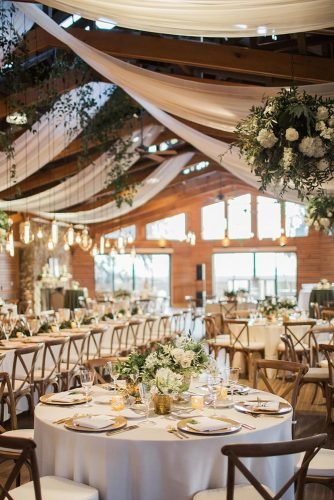 natural wedding décor barn reception decorated with white flowers and greenery brookeimages