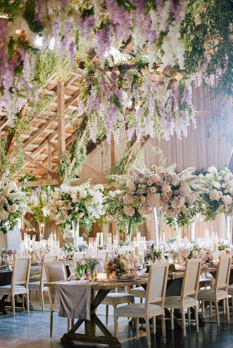 natural wedding décor reception in wooden barn with hanging greenery and flowers sylvie gil photography