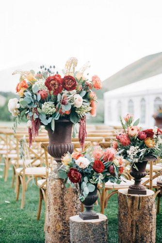 rust wedding color ceremony décor ideas with flowers in vase on wooden stands kendra elise photography