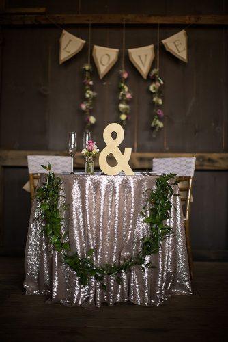 silver wedding decor ideas dark barn reception rustic sparkle tablecloth and greenery mari harsan studios