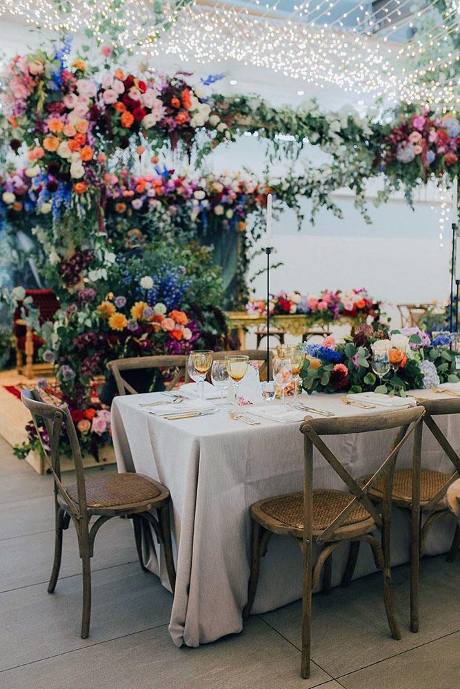 summer wedding trends evening lights on reception decorated with bright flowers michelle du toit