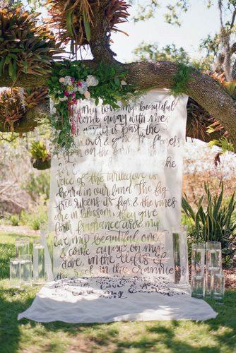 summer wedding trends outdoor ceremony backdrop with greenery and calligraphy signs the ganeys