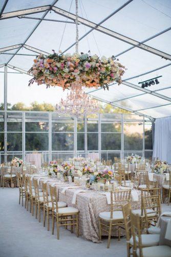 summer wedding trends reception under the tent with bridht flowers on table and haging installation john cain photography