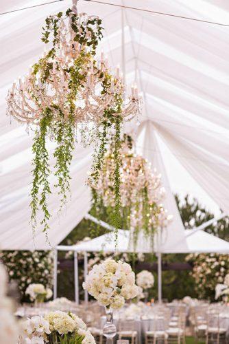 summer wedding trends reception under the tent with elegant chandelier and hanging greenery samuel lippke studios