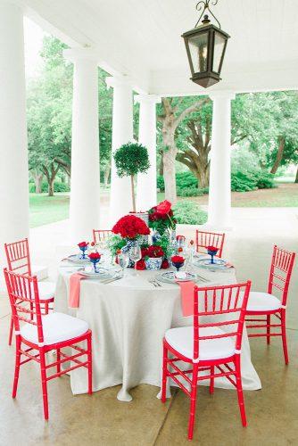 independence day wedding 4th of july outdoor reception round table with red chairs flowers and blue vases jennifer crenshaw photography