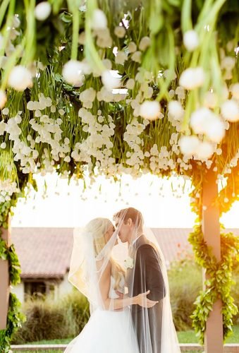 wedding photographers couple under flowers chardphoto
