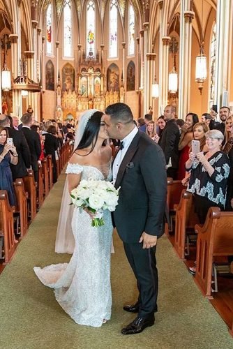 catholic wedding songs newlyweds kissing at the church