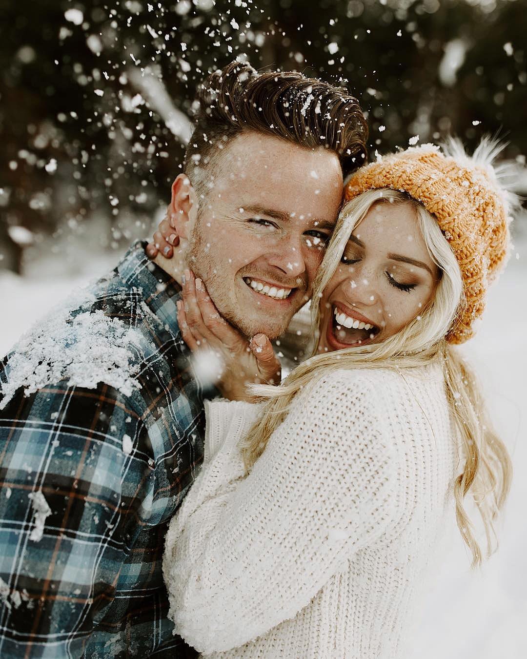 winter engagement photos smiling happy couple snowflakes