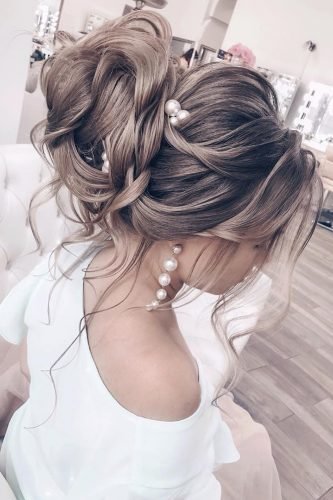 wedding updos textured high bun with loose curls and pearls elstile