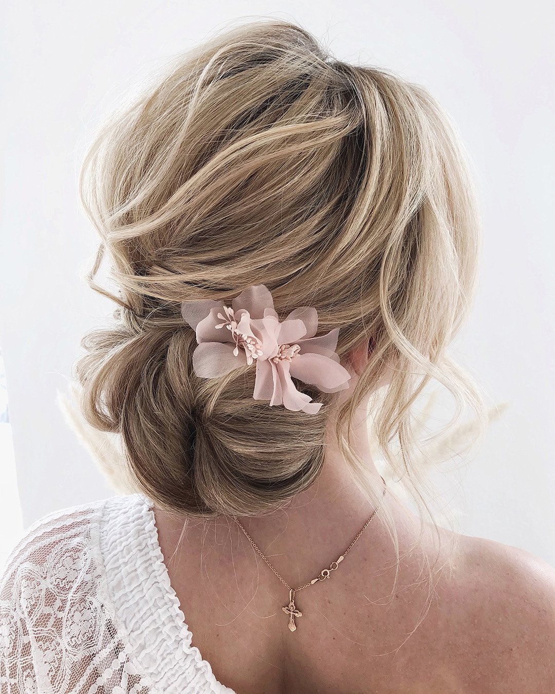 wedding updos for long hair blonde low bun with pink flower juliafratichelli