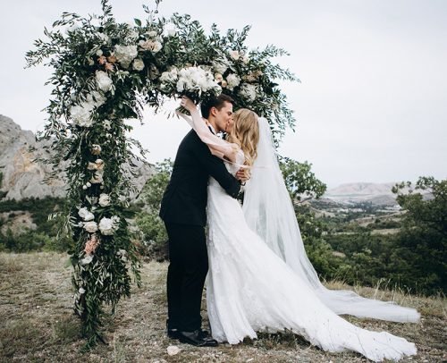 unique wedding readings newlyweds kissing near arch