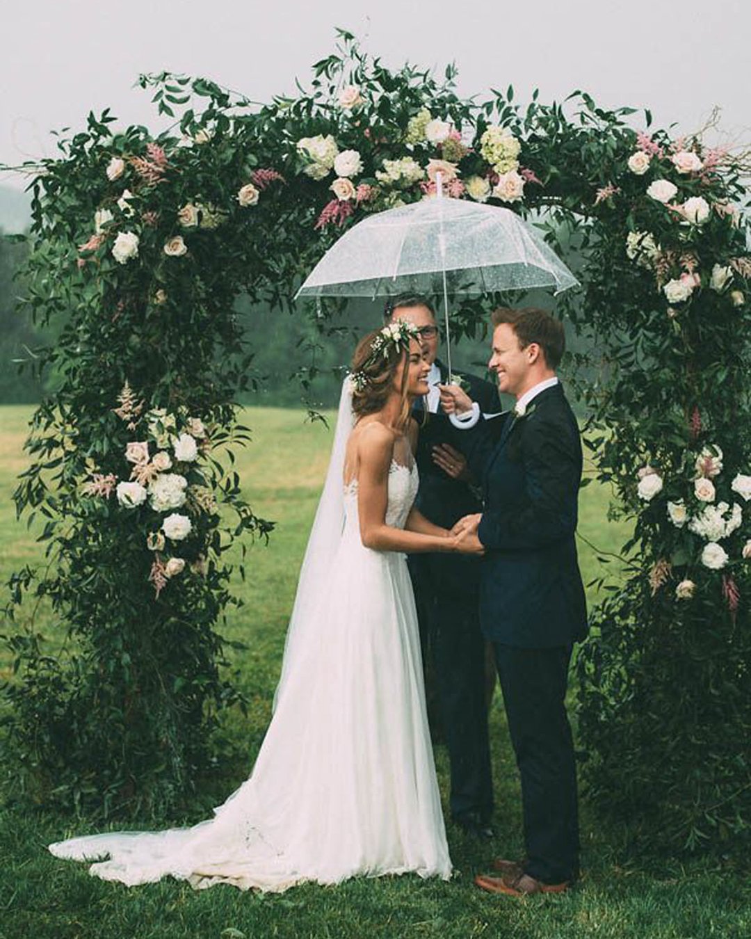 must have wedding photos bride and groom during ceremony near thearch under the rain the image is found