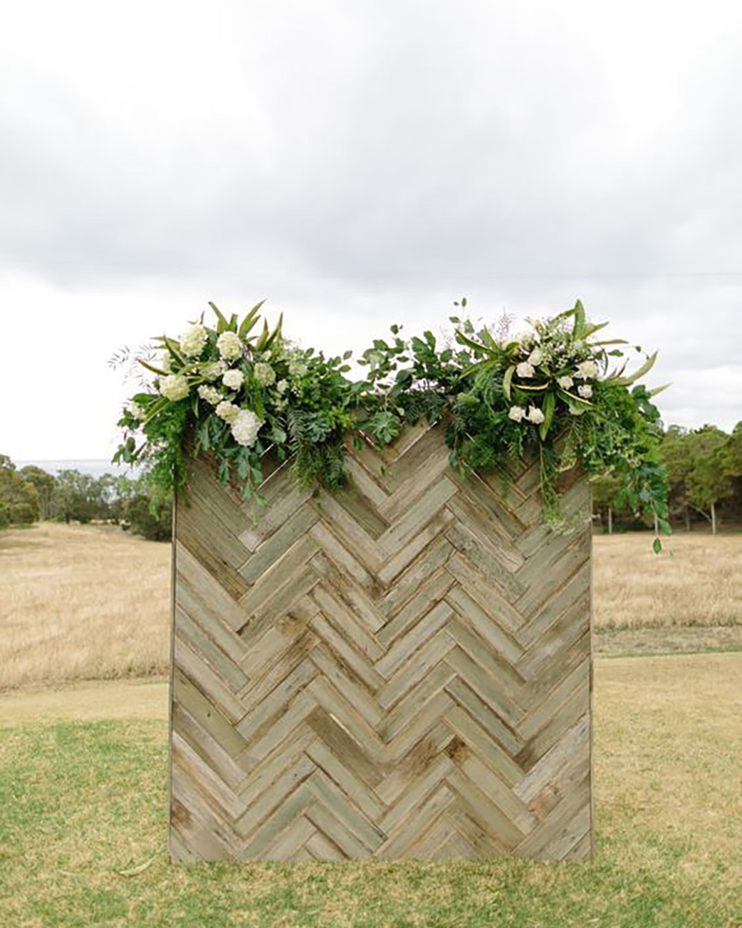 rustic wedding decor backdrop wooden and greenery and white flowers tim coulson