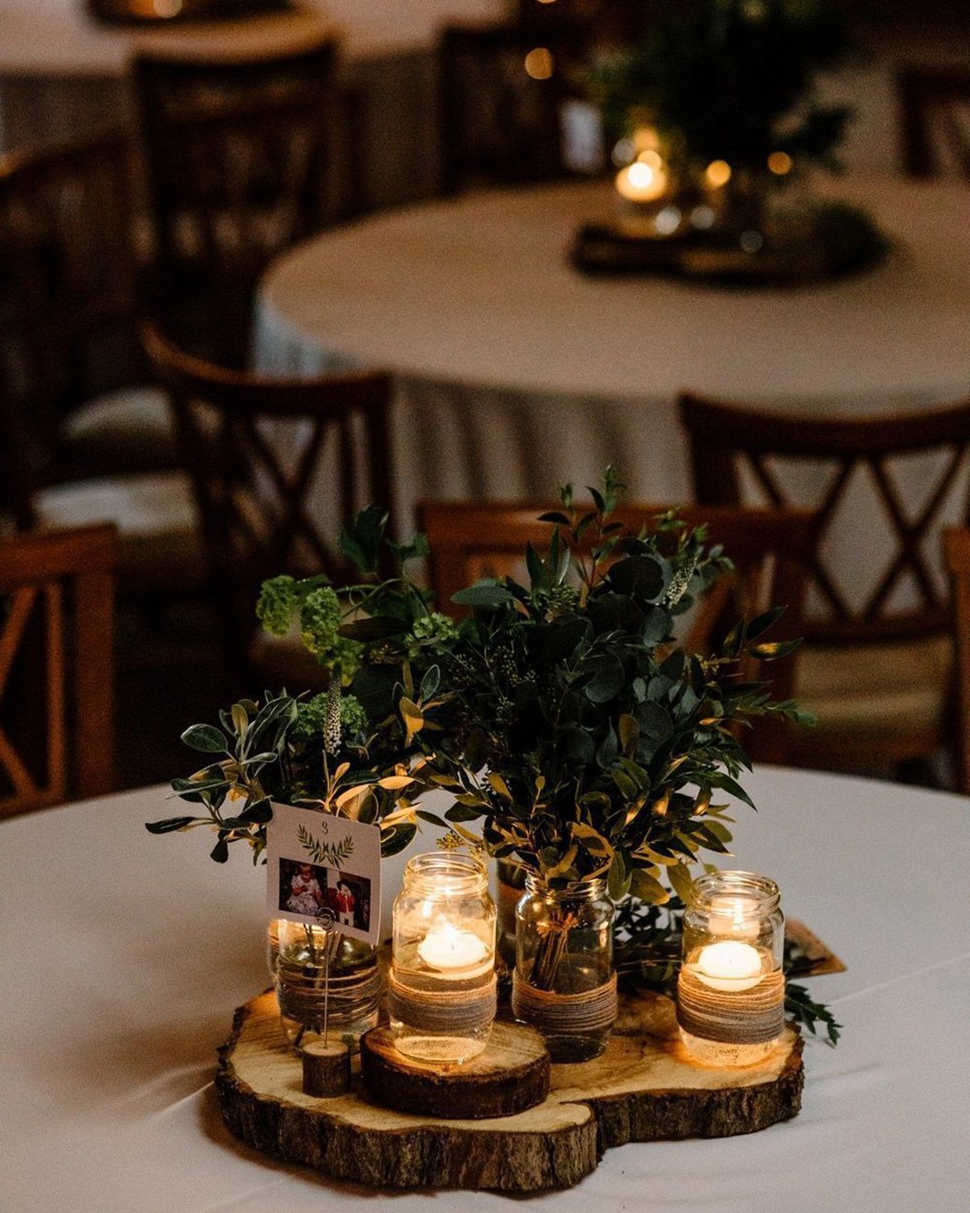 rustic wedding decor candle jars and greenery on wooden slice amy faith photography