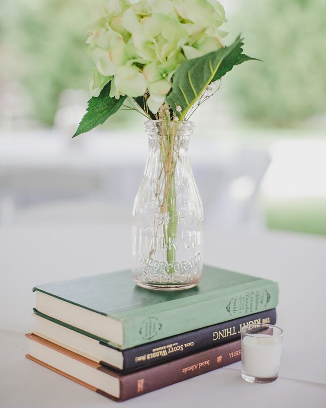 rustic wedding decor centerpiece with books and flowers in glass jennifer thornhill photography