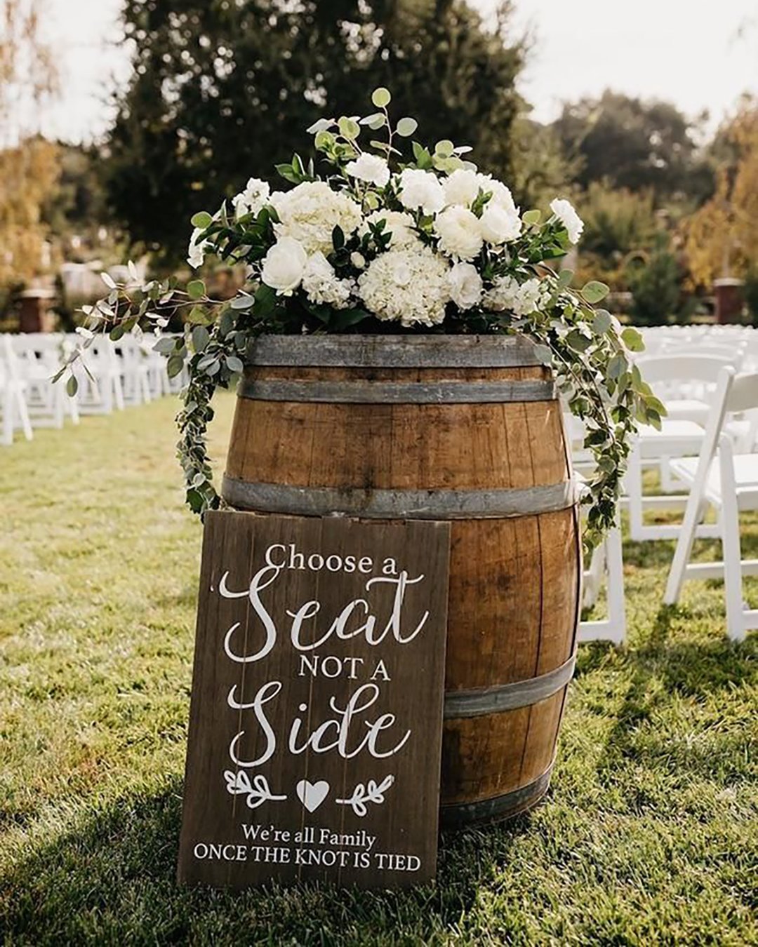 rustic wedding decor for outdoor aisle with winebarrel greenery and white flowers nicole leever photography