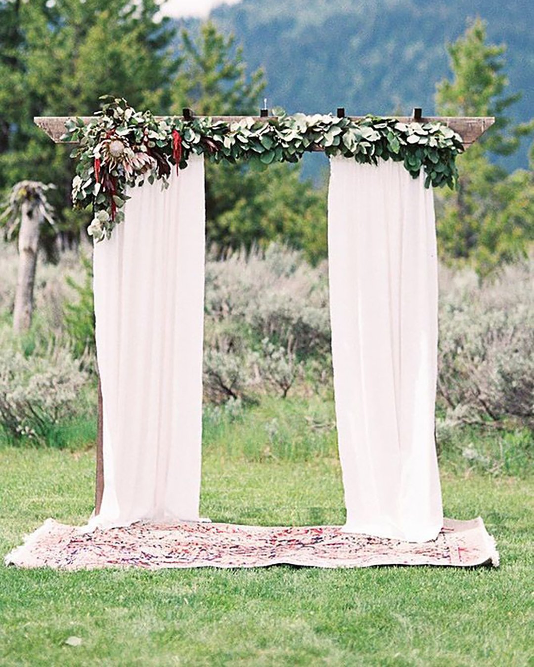 rustic wedding décor wooden arch decorated with greenery and white cloth brie thomason photography
