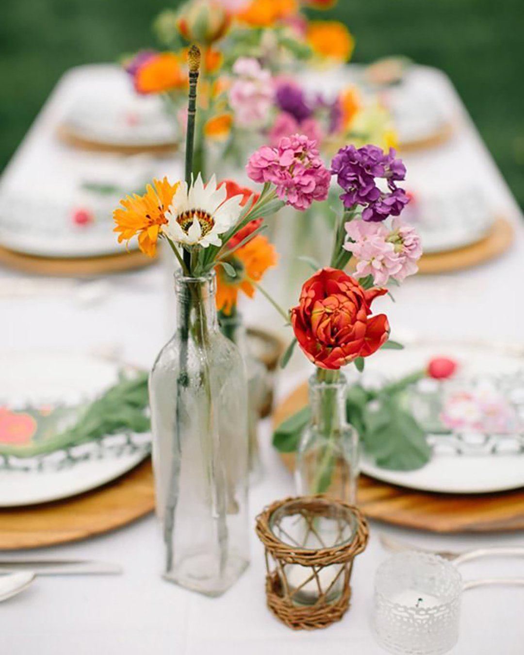 wedding table decorations bright wildflowers in a glass bottles ashley largesse